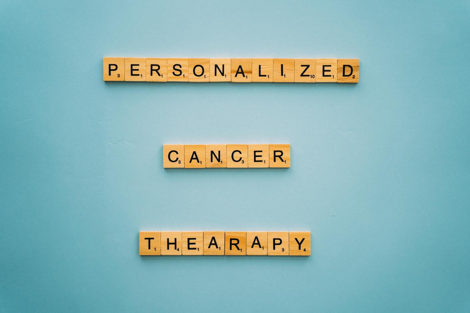 Conceptual image with Scrabble tiles on a blue background spelling 'Personalized Cancer Therapy'.
